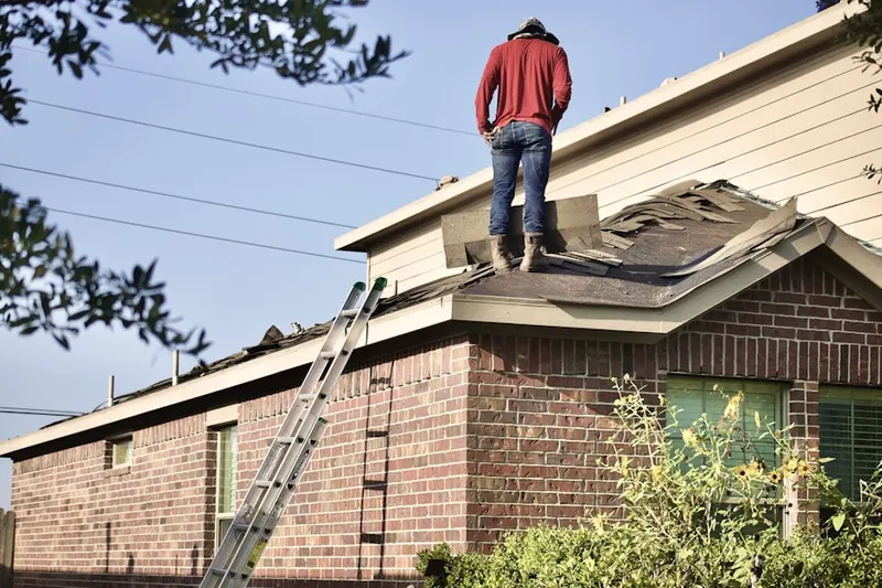 Professional roofer working on a residential roof in Harris Prospect Park